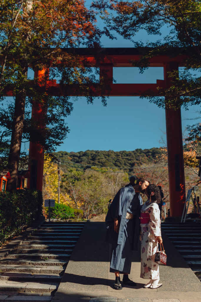 Couple kissing under a red torii near the Maruyama Park, Kyoto, Japan