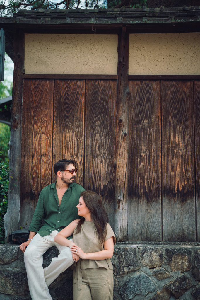 Two customers of a Kyoto couple photoshoot posing before the traditional wooden walls of a house in the center of Kyoto, Japan